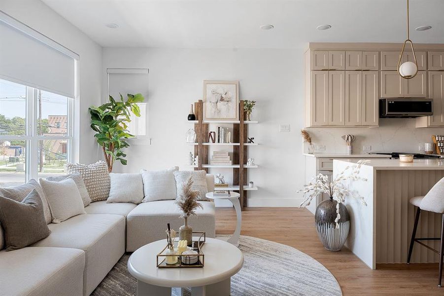 Open-concept living space featuring wood-finish flooring, recessed lighting, and large windows with roller shades
