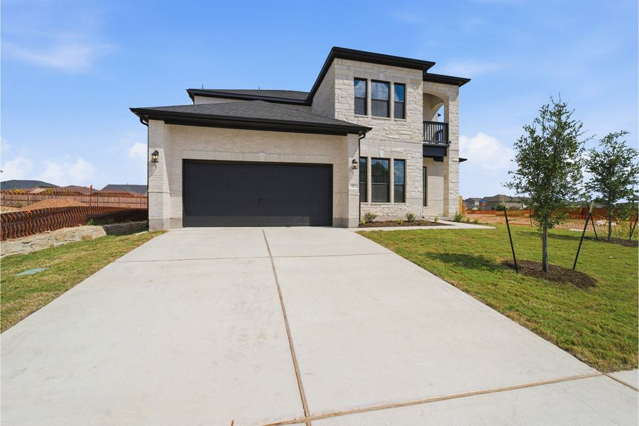 Front exterior of a new home in Sunfield, Buda, TX, highlighting curb appeal (Image 23). Front exterior of a new home in Sunfield, Buda, TX, highlighting curb appeal (Image 23).