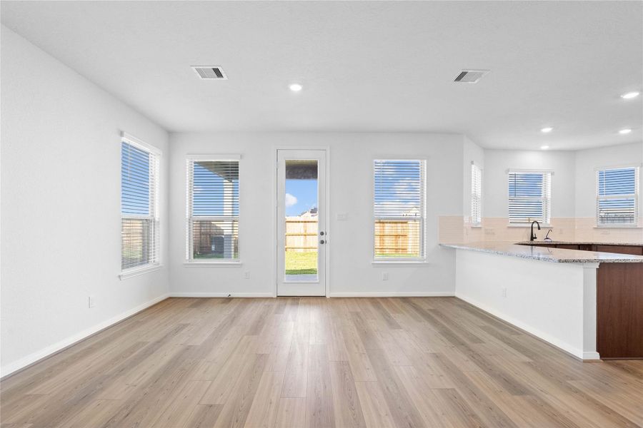 Create lasting memories around the table with family and friends in this inviting dining room! It showcases high ceilings, large windows with privacy blinds, vinyl plank flooring, and recessed lighting for a warm and welcoming atmosphere.
