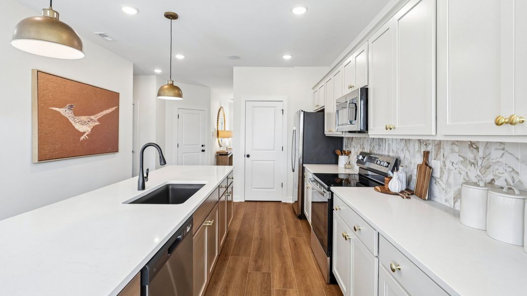 Kitchen with tile backsplash, pendant lighting, and quartz countertops Kitchen with tile backsplash, pendant lighting, and quartz countertops