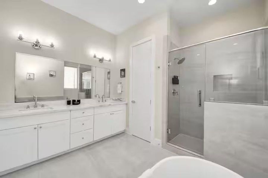 Start and end the day with room to spread out. The primary bath offers an extended vanity, generous storage, and a freestanding soaking tub.