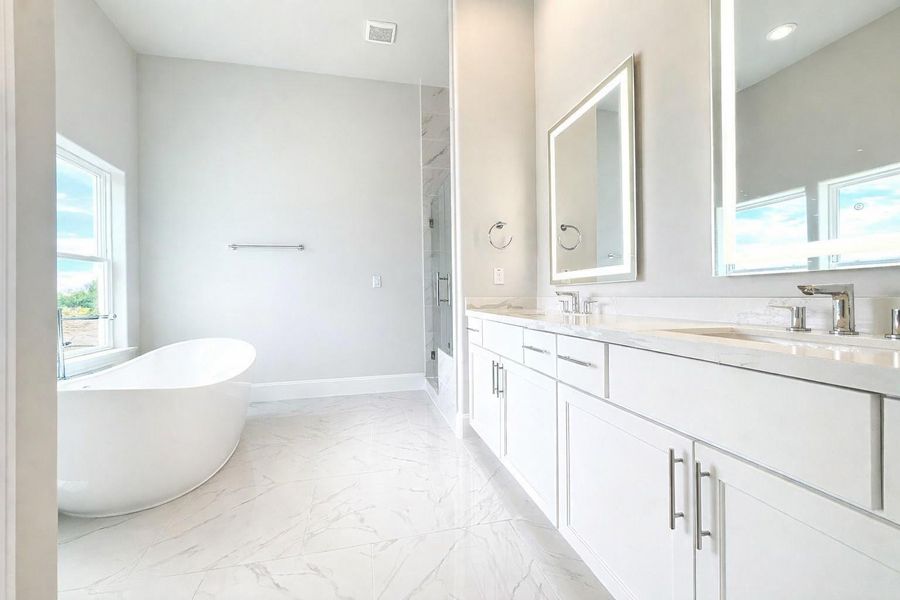 Bathe in natural light in this luxurious primary bathroom.