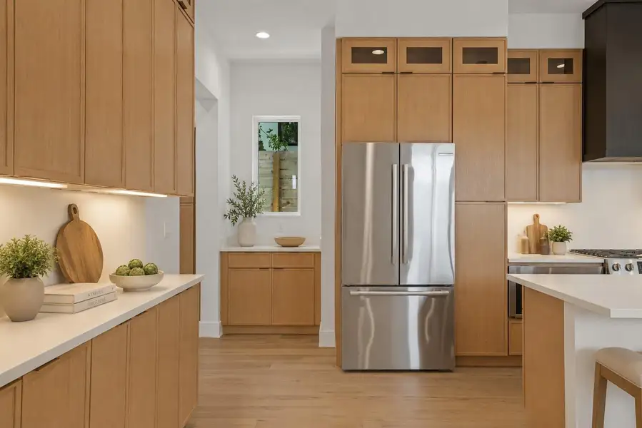 Natural wood cabinetry and a sleek island define this light-filled culinary space.
