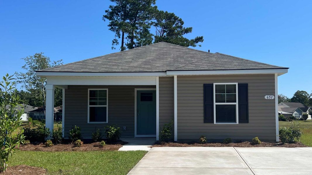 Front exterior of a new home in Sandpiper Place, Myrtle Beach, SC, highlighting curb appeal (Image 1).