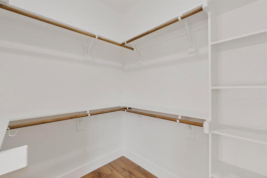 Walk in closet featuring light wood-style floors Walk in closet featuring light wood-style floors
