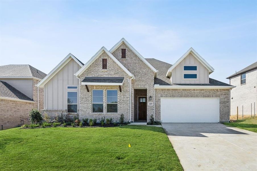 View of front facade featuring a front yard and a garage