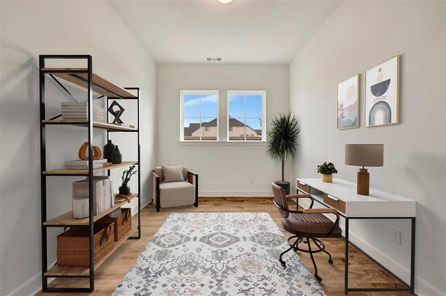 Bright room featuring two windows, wood-finish flooring, and light-colored walls