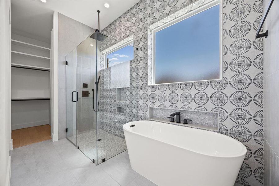 Bathroom with a shower stall, a freestanding bath, a spacious closet, and tile walls Bathroom with a shower stall, a freestanding bath, a spacious closet, and tile walls