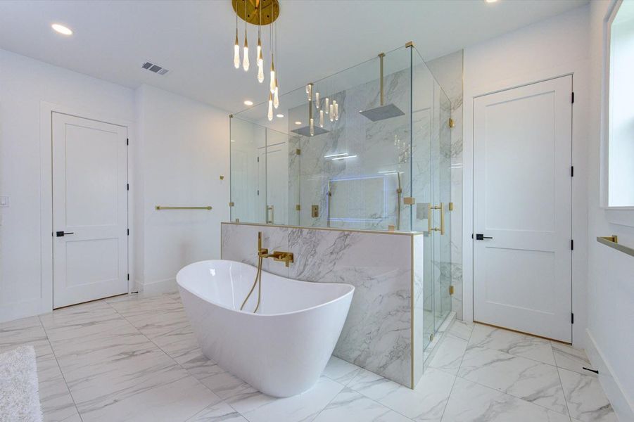 Expansive frameless-glass shower boasts dbl shower heads that glow blue/green/red to indicate water temp.