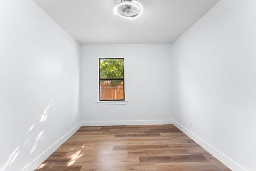 Unfurnished room with wood finished floors and baseboards Unfurnished room with wood finished floors and baseboards