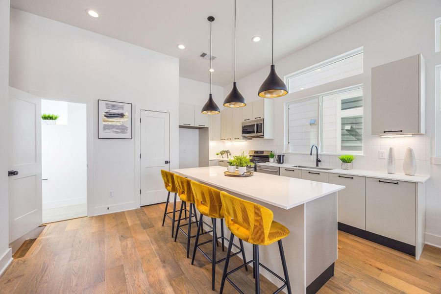 Sleek, modern kitchen with stainless steel appliances, elegant Italian cabinetry, soft closing cabinets/drawers, and a spacious island perfect for entertaining.