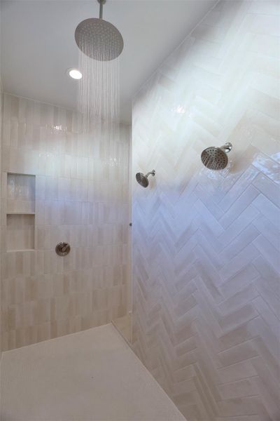 Custom mitered-edge niche provides elegant storage for shower essentials, paired with a rainfall showerhead for a spa-like experience.