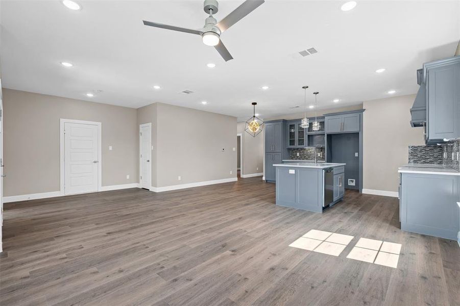 Kitchen featuring a center island with sink, open floor plan, decorative backsplash, decorative light fixtures, and recessed lighting Kitchen featuring a center island with sink, open floor plan, decorative backsplash, decorative light fixtures, and recessed lighting