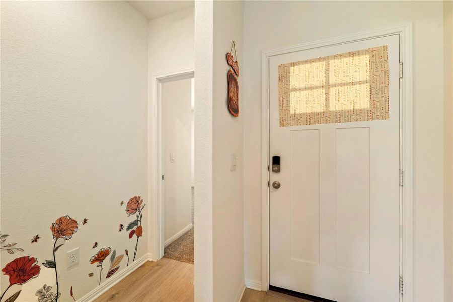 A welcoming entry, with durable wood flooring and crisp white walls, invites residents inward.