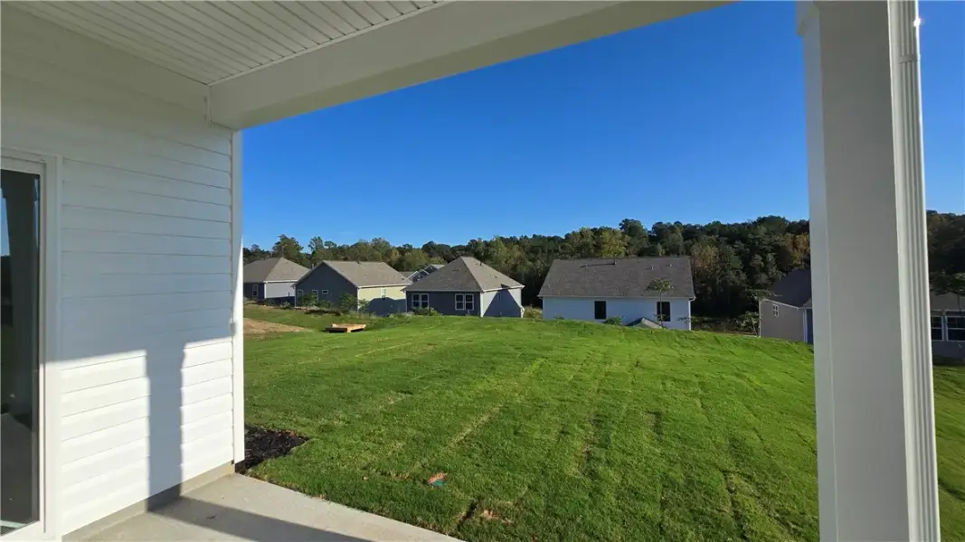 A covered back porch looks out over a sprawling, g