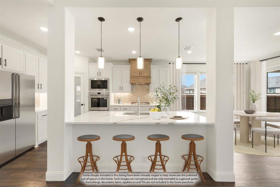Kitchen with large white island, four bar stools, pendant lights, white cabinets, and stainless steel appliances