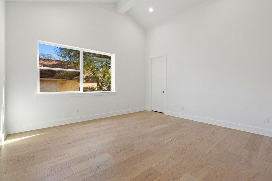 Spare room featuring high vaulted ceiling, light wood-style floors, beam ceiling, and recessed lighting
