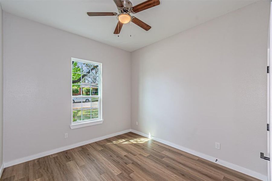 Unfurnished room with wood finished floors and a ceiling fan