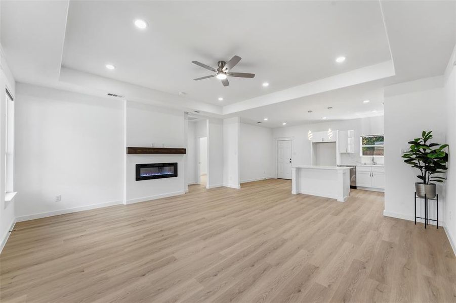 Open concept living area featuring light wood-finish flooring, recessed lighting, and a modern ceiling fan