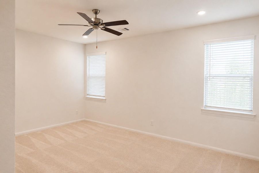 Primary bedroom with a his and her closet