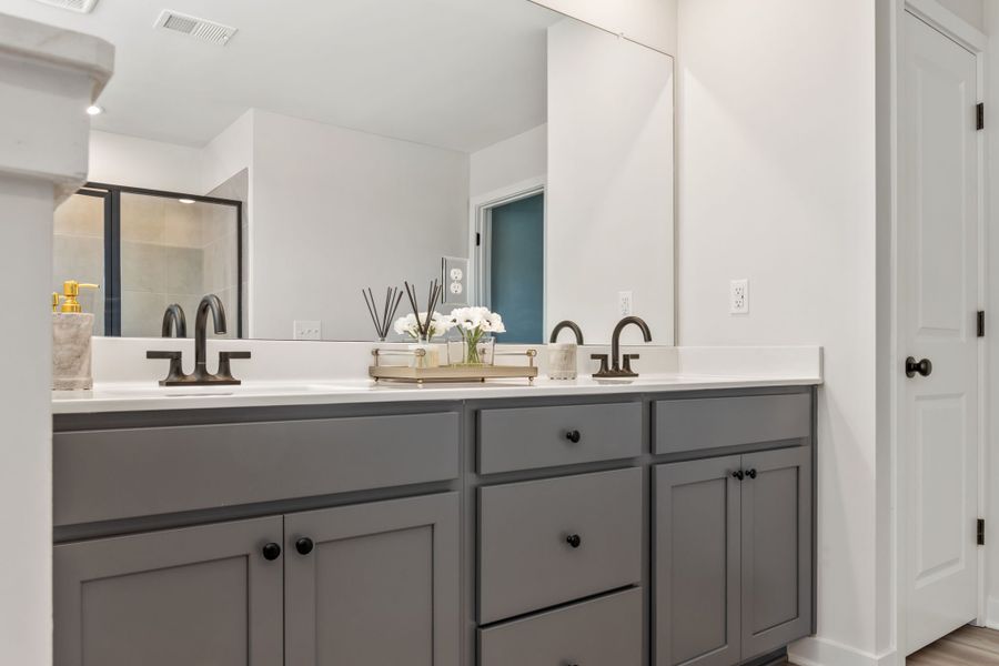 A bathroom with white cabinets.