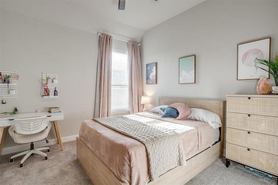 Bedroom featuring ceiling fan, light colored carpet, and vaulted ceiling