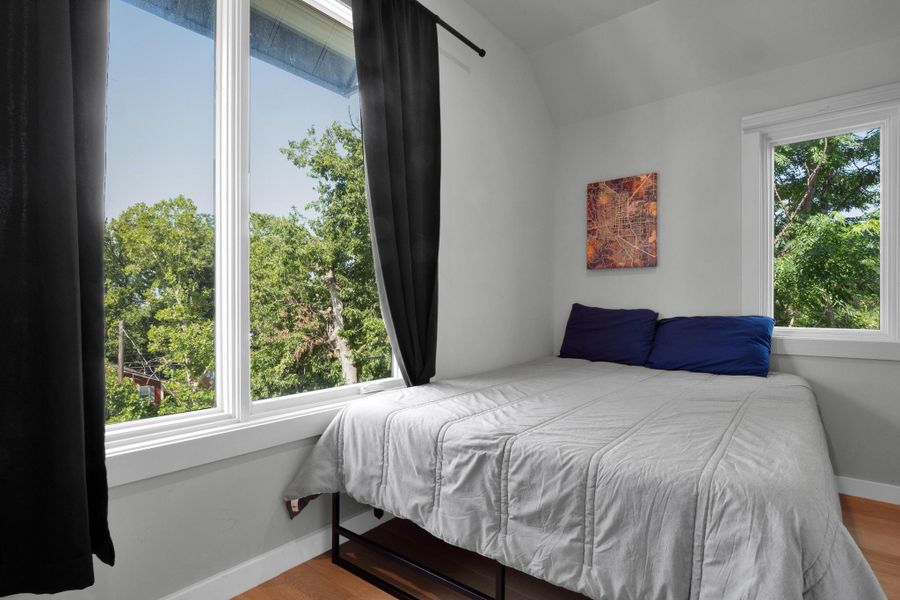 Bedroom featuring lofted ceiling and wood finished floors
