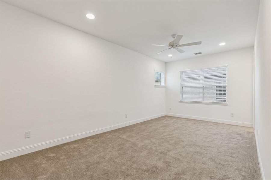 Carpeted empty room with ceiling fan and recessed lighting