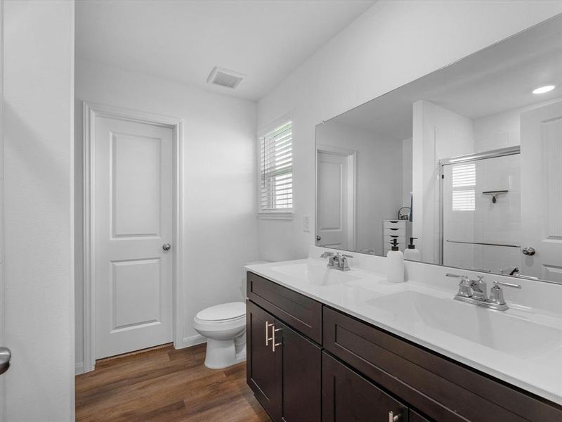 The en-suite bathroom offers a spa-like atmosphere with its elegant design, high end finishes, and tasteful lighting, creating a retreat within your own home.