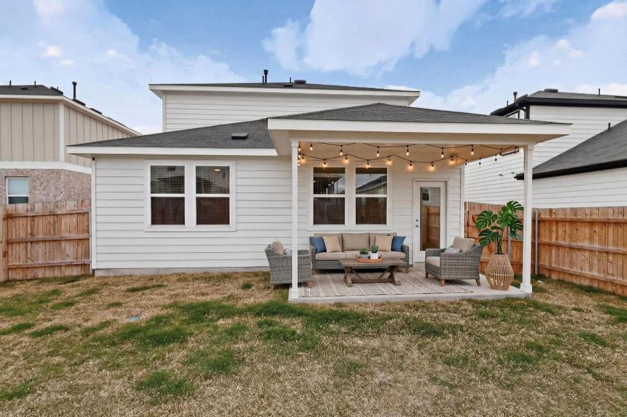 Rear view of house featuring an outdoor lounge area, a fenced backyard, roof with shingles, and a patio area