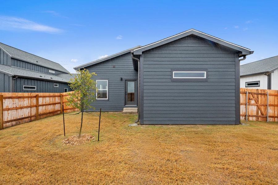 Rear view of house with a fenced backyard
