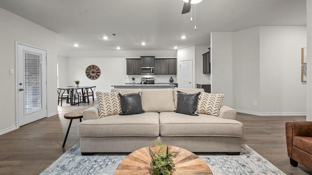 Spacious living area featuring wood-finish flooring and recessed lighting