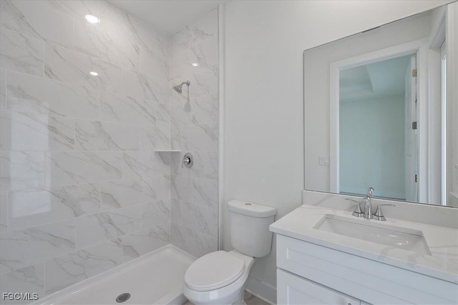 Full bathroom with vanity and a marble finish shower