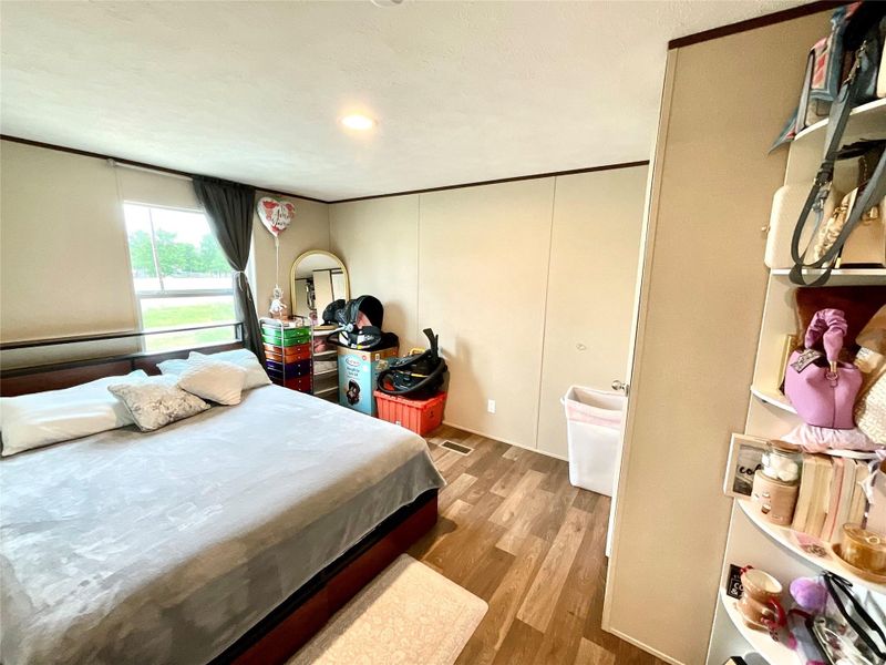 Room 3 with wood-finish flooring, a rectangular window with blinds, and light-colored walls