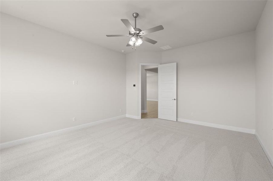 Unfurnished bedroom with light colored carpet and a ceiling fan