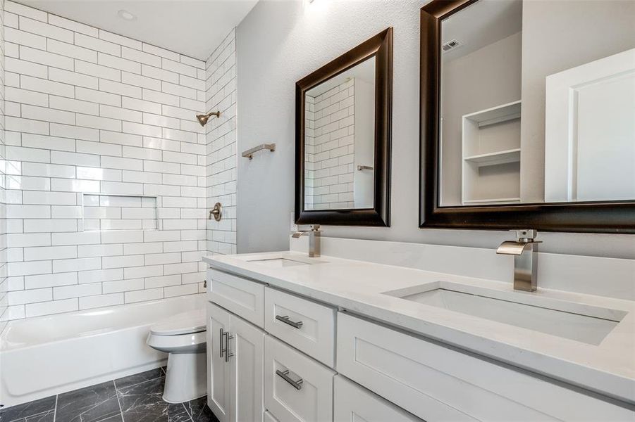 Full bathroom with tiled shower / bath, vanity, and toilet