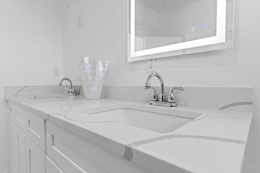 Elegant quartz countertops paired with dual sinks for a sleek modern look.