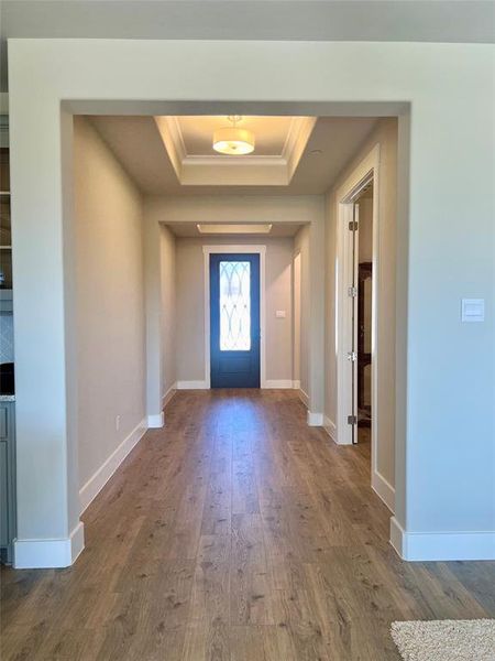 Welcome home...Entrance foyer with hardwood / wood-style floors, a raised ceiling, and crown molding