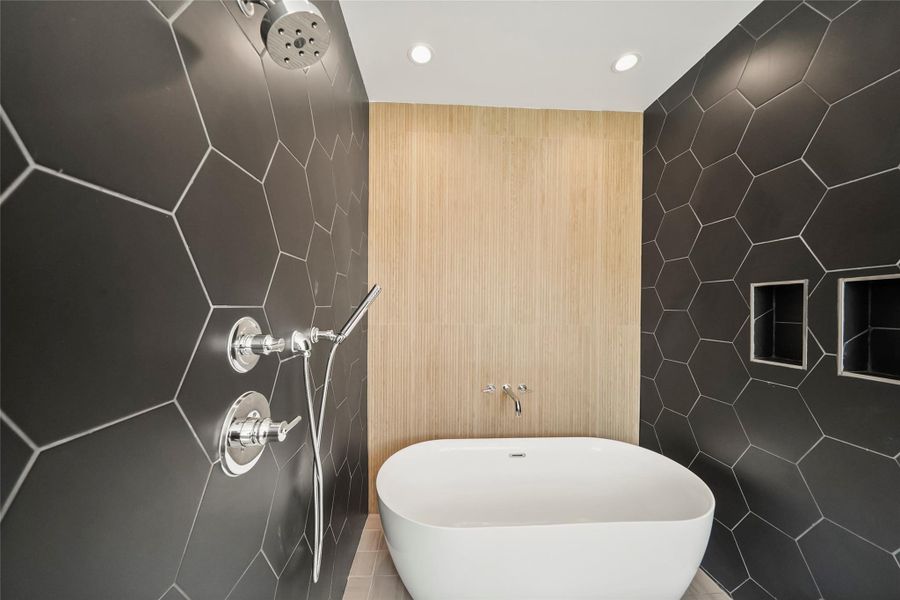 Luxurious ensuite featuring custom tilework and a sleek freestanding soaking tub. Luxurious ensuite featuring custom tilework and a sleek freestanding soaking tub.