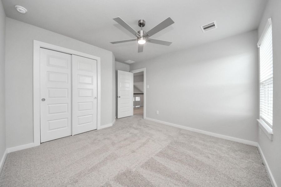 Generously sized secondary bedrooms featuring spacious closets, soft and inviting carpeting underfoot, large windows allowing plenty of natural light, and the added touch of privacy blinds for your personal retreat.