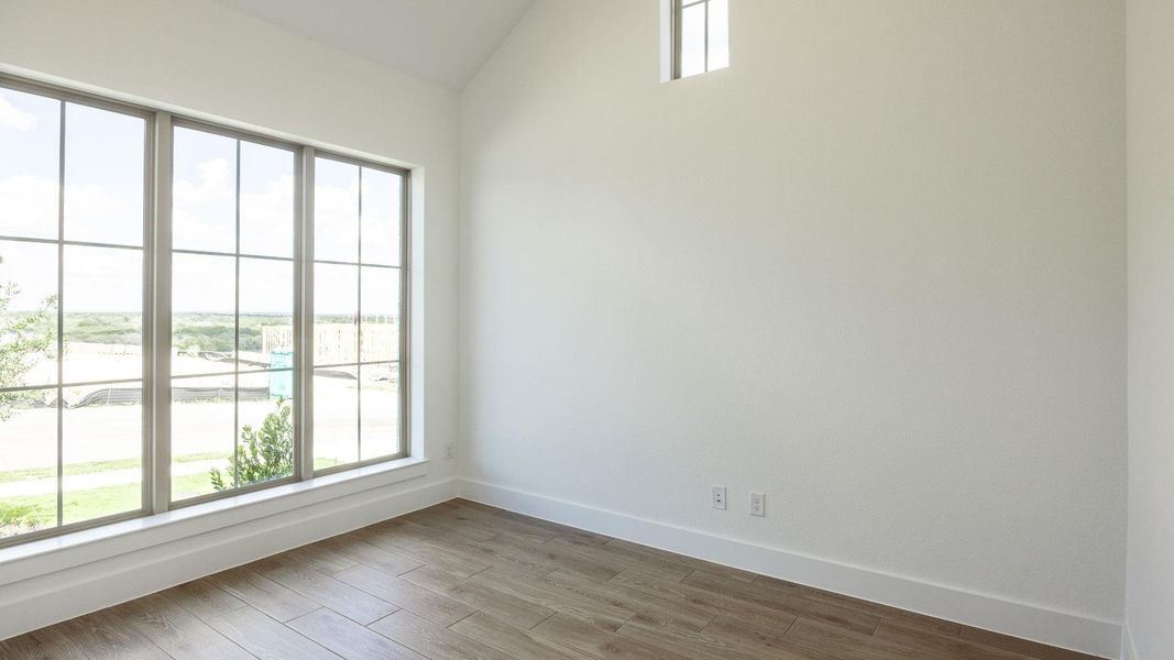 Spare room with wood finished floors and vaulted ceiling Spare room with wood finished floors and vaulted ceiling