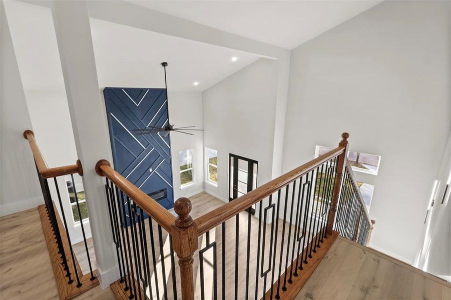 Stairway with hardwood / wood-style floors and ceiling fan