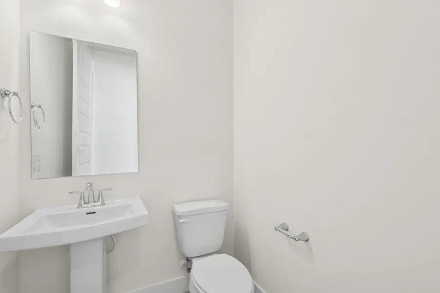 Half bath featuring toilet and baseboards Half bath featuring toilet and baseboards