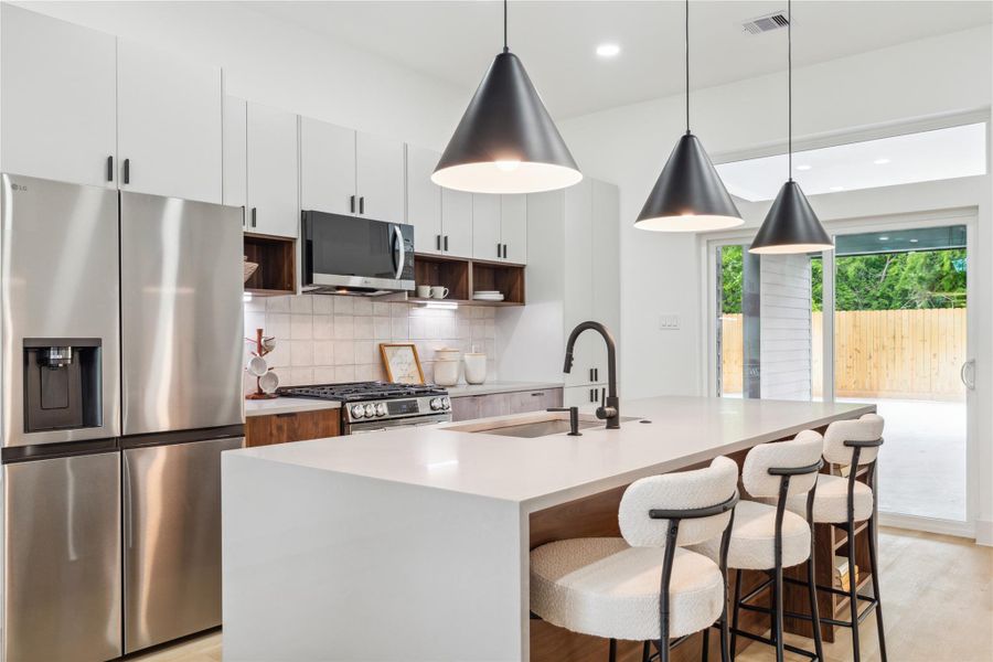 With striking pendant lighting, sleek finishes, and a spacious island, this kitchen is designed to host everything from lively gatherings to quiet, memorable moments. With striking pendant lighting, sleek finishes, and a spacious island, this kitchen is designed to host everything from lively gatherings to quiet, memorable moments.