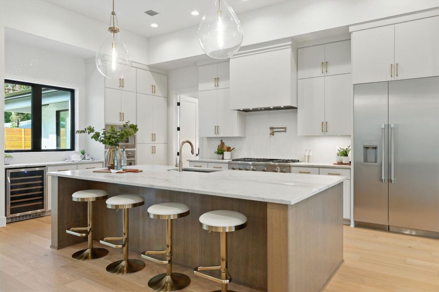 Kitchen with stainless steel appliances, beverage cooler, white cabinets, and recessed lighting Kitchen with stainless steel appliances, beverage cooler, white cabinets, and recessed lighting