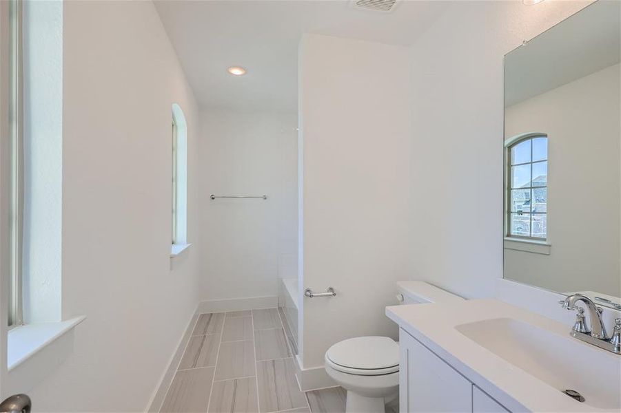 Bathroom featuring vanity, tile patterned flooring, and toilet