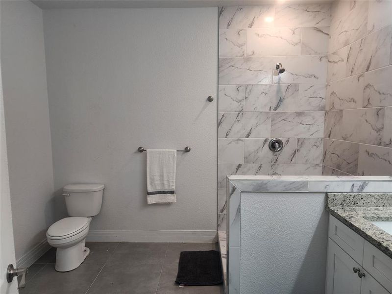 Bathroom with vanity, toilet, and tile patterned floors