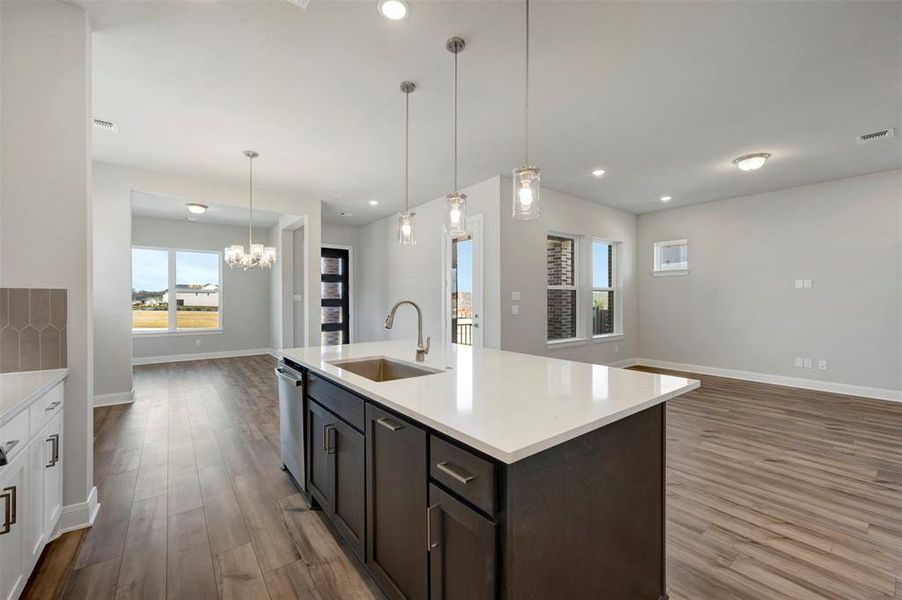 Kitchen with open floor plan, dark wood-style flooring, and light stone countertops