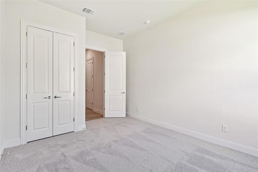 Unfurnished bedroom featuring light colored carpet and a closet