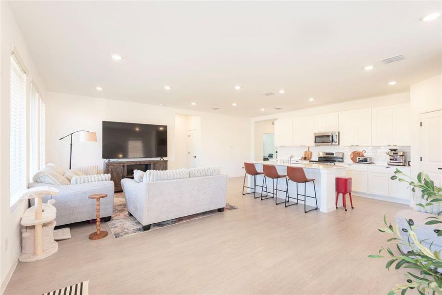 Living room featuring light wood-style flooring and recessed lighting Living room featuring light wood-style flooring and recessed lighting
